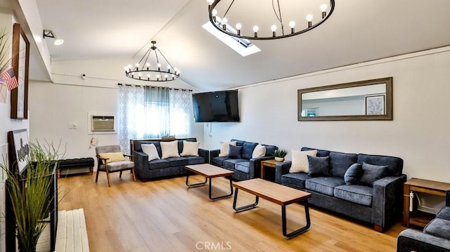 living room featuring a wall mounted AC, a chandelier, vaulted ceiling, and hardwood / wood-style flooring