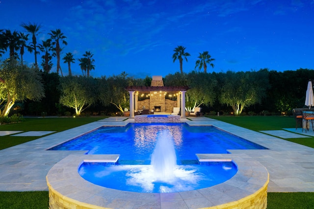 view of pool with a patio, an in ground hot tub, pool water feature, and a lawn