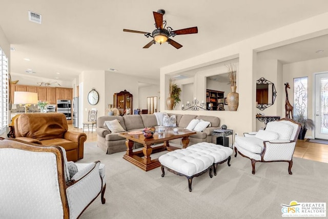 living room with light carpet and ceiling fan