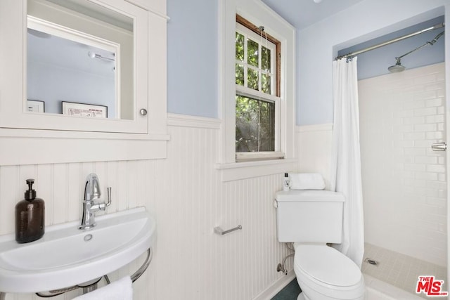 bathroom with a shower with curtain, toilet, and sink