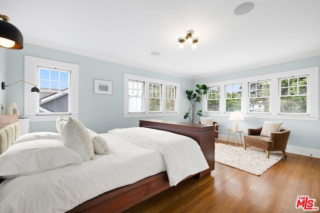 bedroom featuring dark hardwood / wood-style floors, multiple windows, and ornamental molding