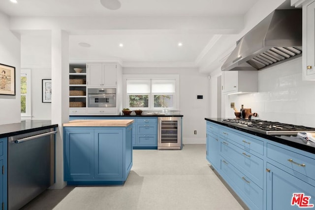 kitchen featuring white cabinetry, wall chimney exhaust hood, stainless steel appliances, wine cooler, and blue cabinets