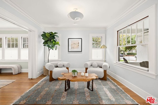 living area with wood-type flooring and crown molding