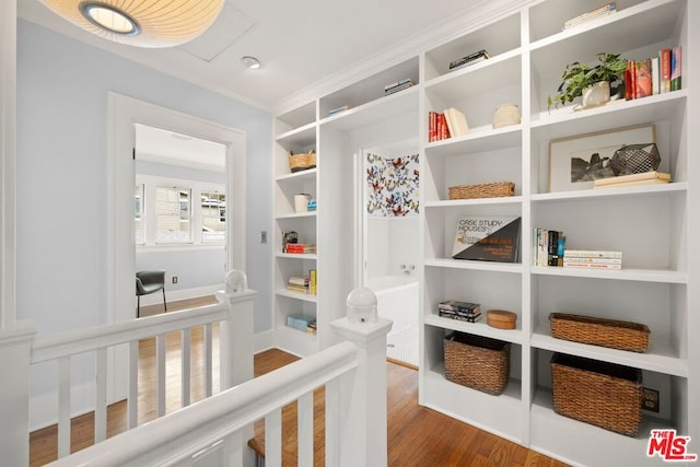 hallway featuring hardwood / wood-style flooring and ornamental molding