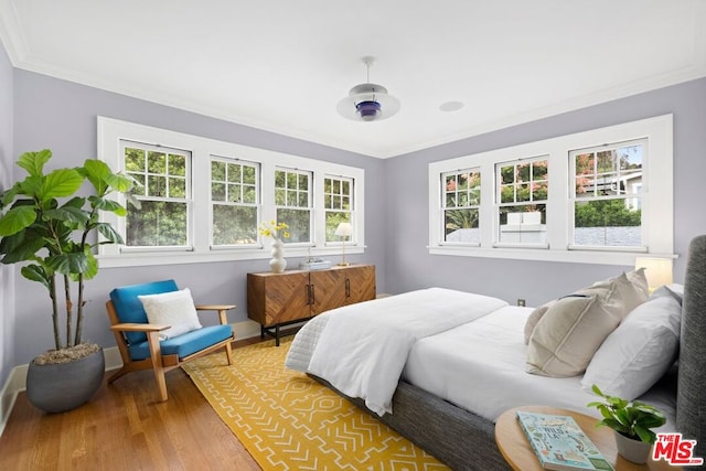 bedroom featuring wood-type flooring, ceiling fan, and crown molding