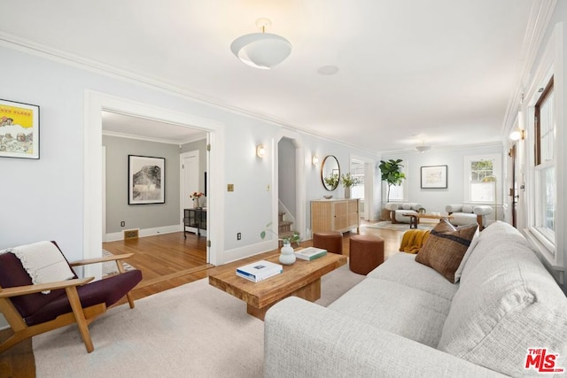 living room with crown molding and light wood-type flooring