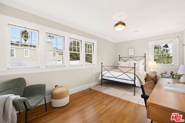 bedroom featuring crown molding and wood-type flooring