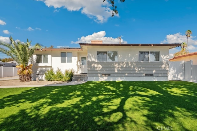 rear view of property featuring a lawn