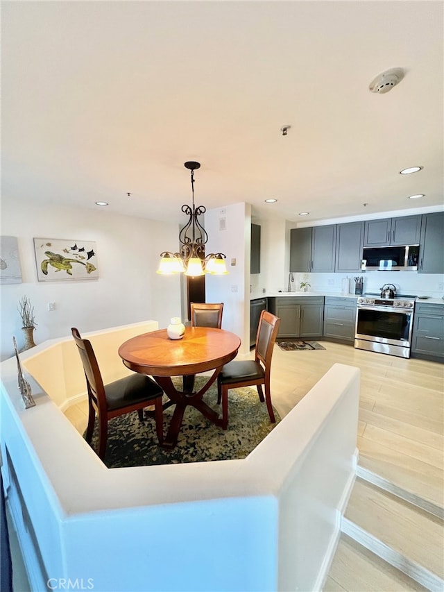 dining space featuring light hardwood / wood-style floors and an inviting chandelier