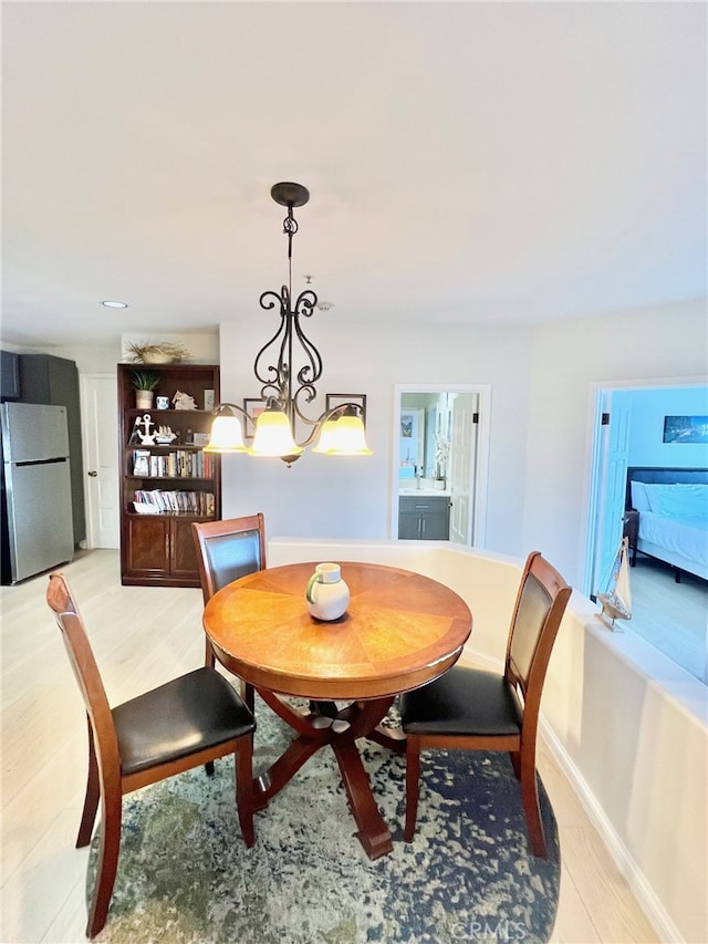 dining room with light hardwood / wood-style floors and an inviting chandelier