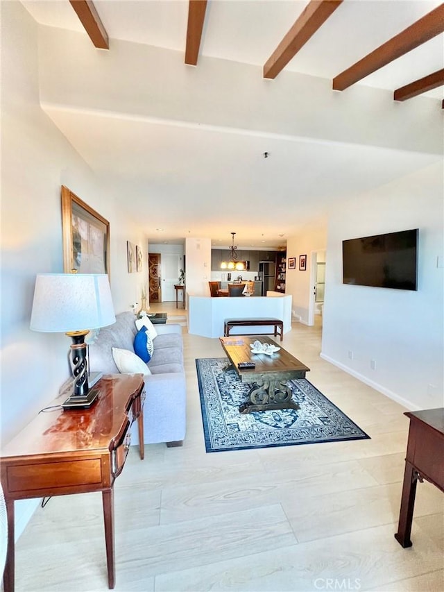 36 Camino De Flores Unit 69, Avalon, CA 90704 - living area with beamed ceiling, a chandelier, and baseboards