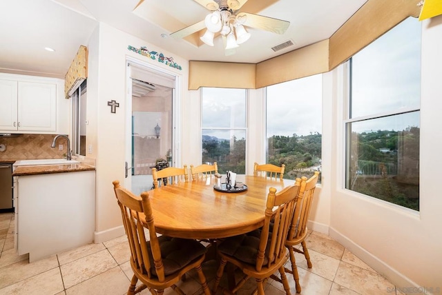 dining room with sink, light tile patterned floors, and ceiling fan