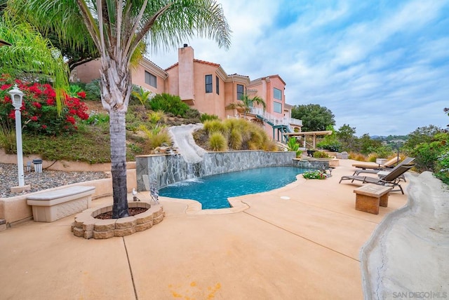 view of swimming pool featuring a patio area, pool water feature, and a water slide