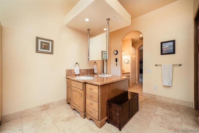 kitchen with sink, light tile patterned flooring, and light stone counters