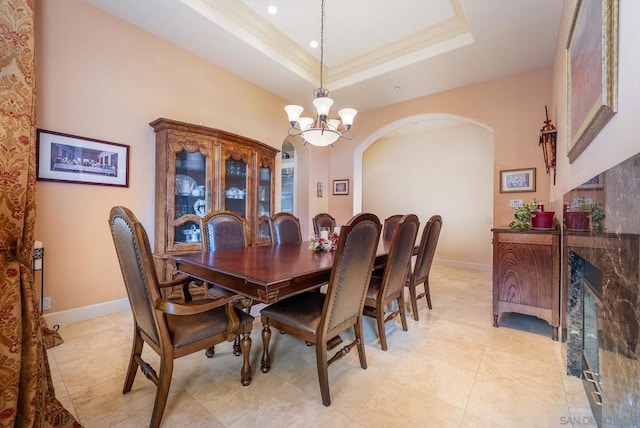 dining area featuring a notable chandelier and a raised ceiling