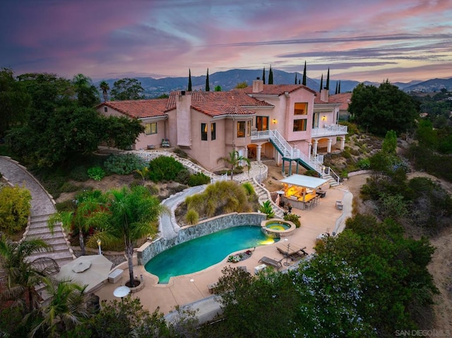 pool at dusk featuring a patio