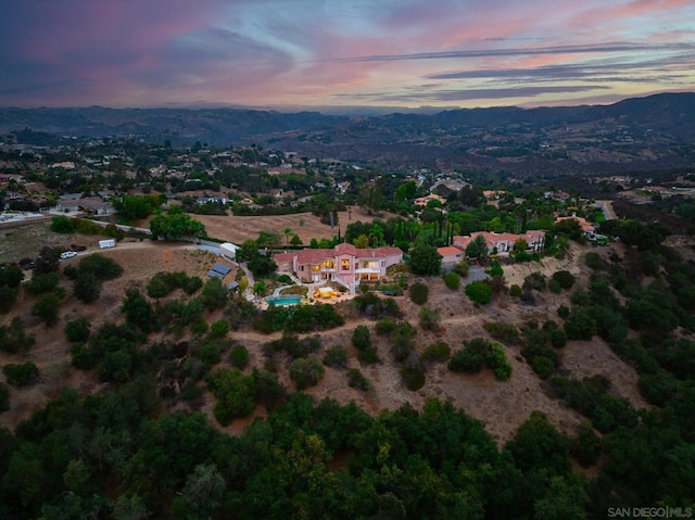 aerial view at dusk featuring a mountain view