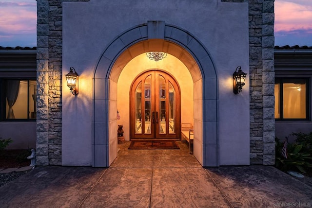 exterior entry at dusk featuring french doors