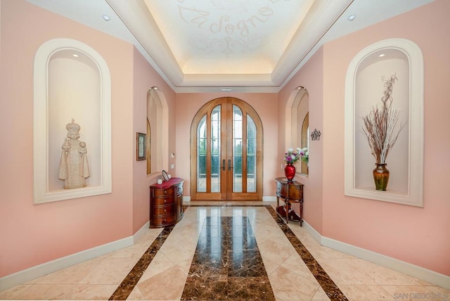 entryway with french doors and a raised ceiling