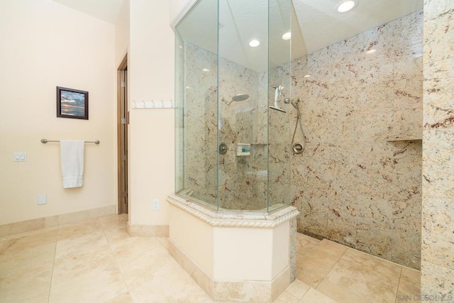 bathroom with a tile shower and tile patterned floors