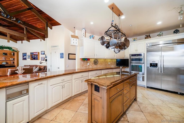 kitchen featuring kitchen peninsula, stainless steel appliances, white cabinets, light stone counters, and light tile patterned floors