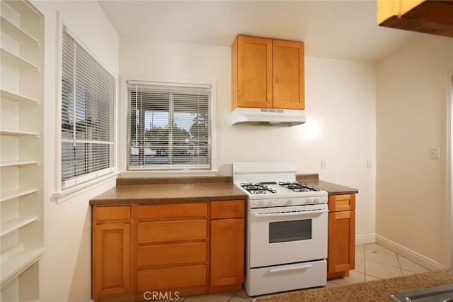 kitchen featuring white range with gas stovetop and light tile patterned floors