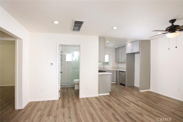 kitchen featuring sink, gray cabinets, ceiling fan, light hardwood / wood-style floors, and stainless steel dishwasher