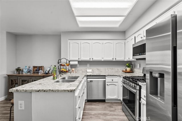 kitchen featuring stainless steel appliances, sink, light wood-type flooring, and white cabinets