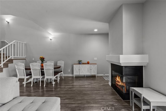 dining space with a multi sided fireplace and dark hardwood / wood-style floors