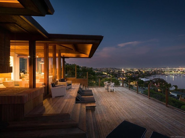 deck at dusk featuring a water view