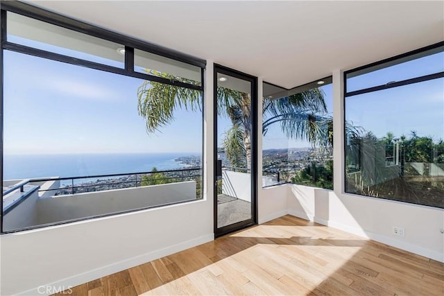 unfurnished sunroom featuring a water view