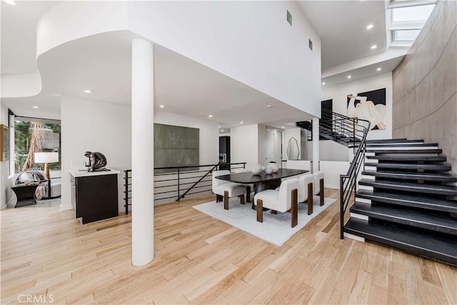 dining room featuring light hardwood / wood-style floors and a high ceiling