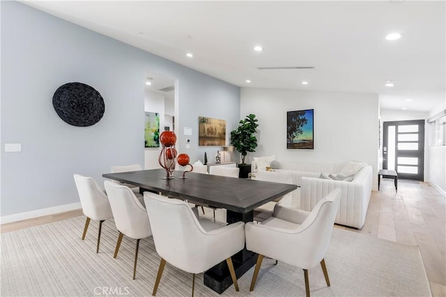 dining room with vaulted ceiling and light wood-type flooring