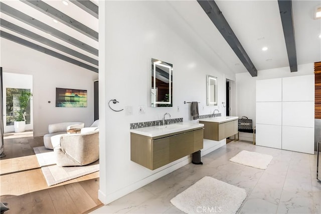 bathroom featuring lofted ceiling with beams and vanity