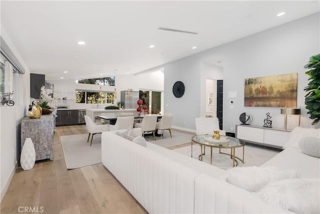 living room with vaulted ceiling and light wood-type flooring