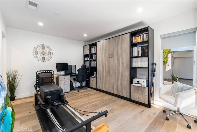 exercise room with light wood-type flooring