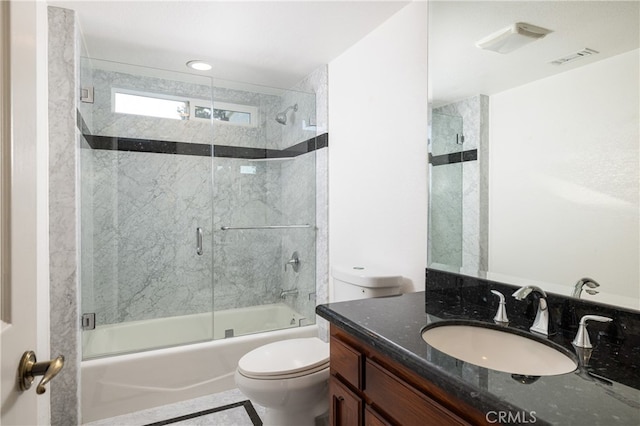 full bathroom featuring toilet, vanity, and shower / bath combination with glass door