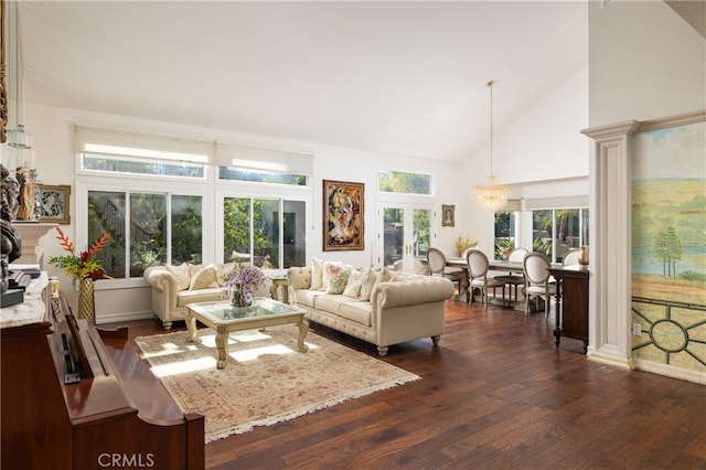 living room with an inviting chandelier, dark wood-type flooring, and high vaulted ceiling