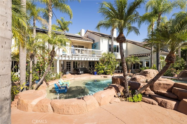 rear view of house with a patio area and a balcony