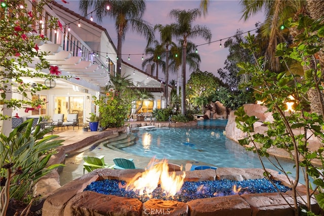 pool at dusk with a patio area