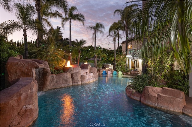 pool at dusk with pool water feature