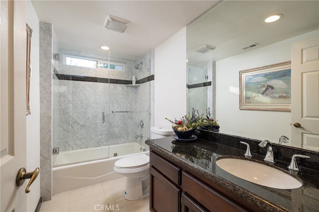 full bathroom featuring combined bath / shower with glass door, a textured ceiling, toilet, tile patterned floors, and vanity