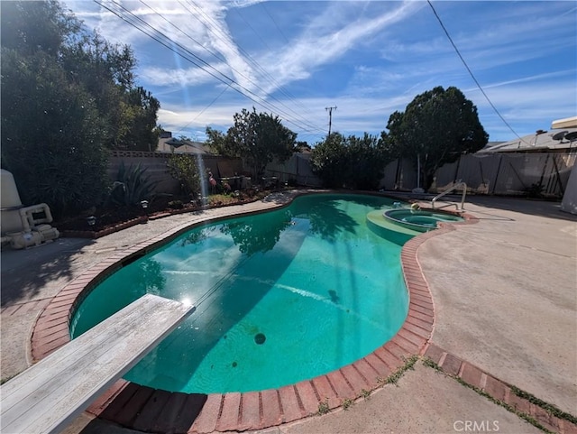 view of pool with a diving board, a patio area, and an in ground hot tub