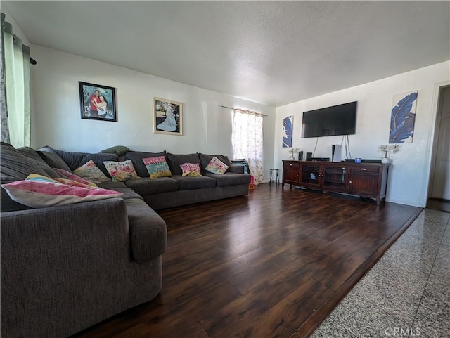 living room featuring a textured ceiling and dark wood-type flooring