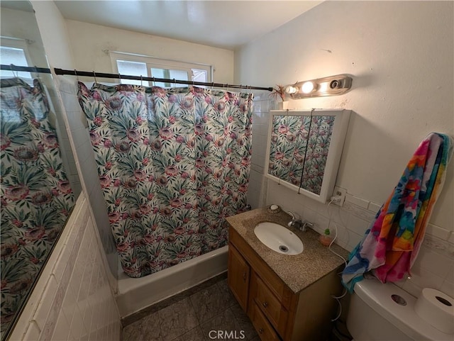 bathroom featuring vanity, toilet, and tile walls