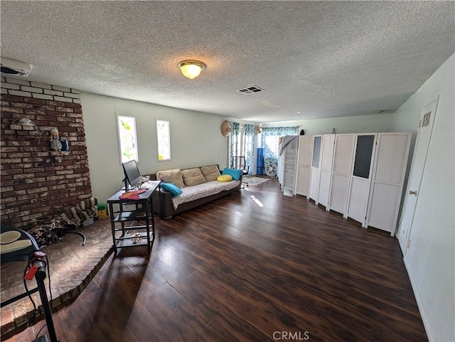 living room featuring a textured ceiling and dark hardwood / wood-style flooring