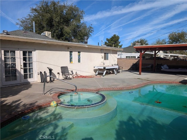 view of swimming pool with an in ground hot tub, french doors, and a patio