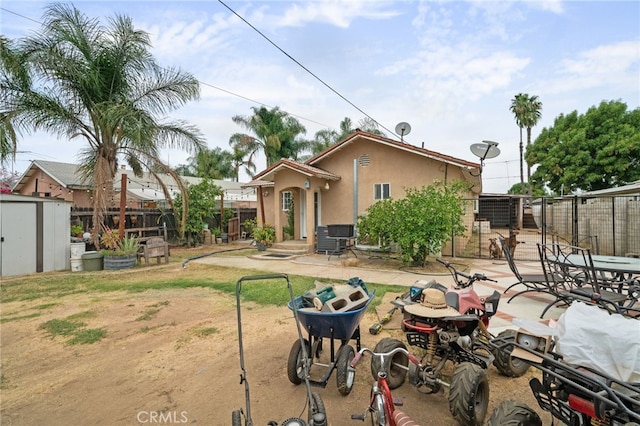 rear view of house featuring central air condition unit, a patio area, and a storage shed