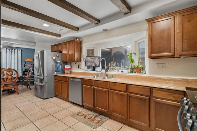 kitchen with beam ceiling, sink, stainless steel appliances, and light tile patterned flooring