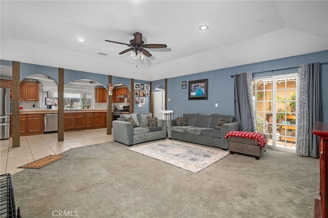 carpeted living room with ceiling fan and sink